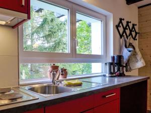 a kitchen with a sink and two windows at Holiday Home Chalet Ninette by Interhome in Eischoll