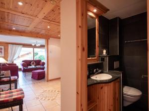 ein Badezimmer mit einem Waschbecken und ein Wohnzimmer in der Unterkunft Apartment Ambre-6 by Interhome in Villars-sur-Ollon