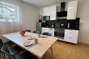 a kitchen with a wooden table with chairs and a dining room at Ferienhaus - Das Seigendorfer in Hirschaid