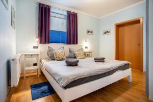 a bedroom with a large bed and a window at Haus Frohsinn - Wohnung 6 in Binz