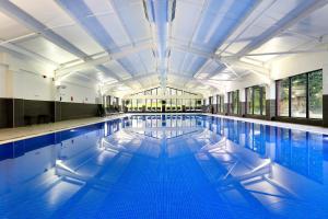 a large swimming pool with blue water at Macdonald Hill Valley Hotel, Spa & Golf Resort in Whitchurch