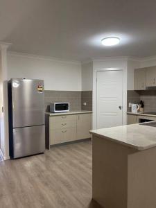 an empty kitchen with a stainless steel refrigerator at Stay at Bambas in Kingston