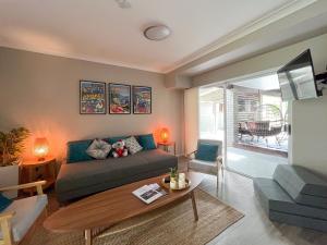 a living room with a couch and a table at Lake-view Retreat w Spa, nearby Beaches & Shopping in the Central Coast in Lakeside