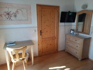a room with a wooden door and a table and a dresser at Asbichlerhof in Bad Endorf