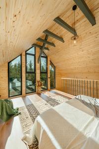 a bedroom with a bed in a room with windows at Apusenity- Refugiu modern în inima naturii, aproape de Cluj in Cluj-Napoca