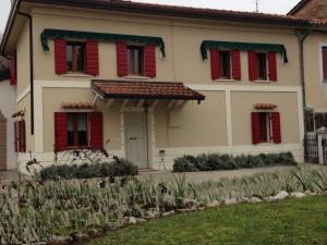een huis met rode luiken erop bij B&B Casa Linda in Pradipozzo