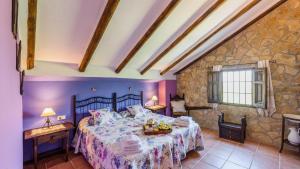 a bedroom with a bed and a stone wall at Cortijo Casablanca Priego de Cordoba by Ruralidays in Priego de Córdoba +31 photos