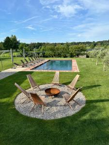 a group of chairs and a table next to a pool at Ca Nova Agriturismo in Castellaro