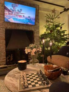 ein Wohnzimmer mit einem Schachbrett auf einem Tisch vor einem Kamin in der Unterkunft Boho Chic Cottage & Wild Garden nr Soho Farmhouse in Steeple Aston