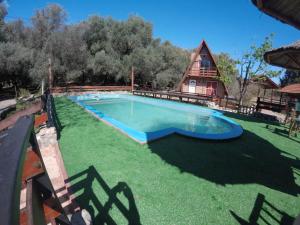 a large swimming pool in the yard of a house at Alpinas San Lorenzo in Merlo