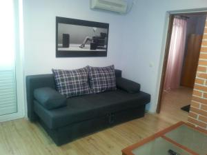 a couch in a living room with a picture on the wall at Apartments Roncevic in Zadar