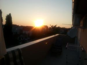 a view of the sunset from the balcony of a building at Apartments Roncevic in Zadar