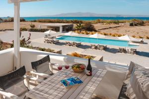 a table with a bowl of fruit and a glass of wine at Archon Seaside Retreat in Plaka