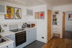 a kitchen with white counters and a stove top oven at Fifies - Your Seaside Bolthole in Pittenweem +6 photos