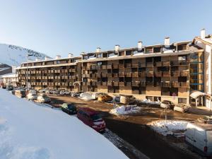 a large building with cars parked in a parking lot at Studio 4 pers proche pistes à Saint-Lary - FR-1-296-370 in Saint-Lary-Soulan