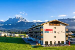 サンクト・ジョアン・イン・チロルにあるCOOEE alpin Hotel Kitzbüheler Alpenの山を背景にした Google の看板がある建物