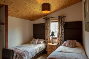 a bedroom with two beds and a window at Harvest 18 Lodge, Yellowtop Country Park in Selby