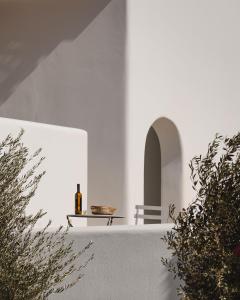 a bottle of wine sitting on a white wall at Archon Seaside Retreat in Plaka