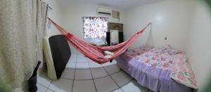 a room with a bed and a hammock in a room at Casa de Praia Pindobal in Santarém
