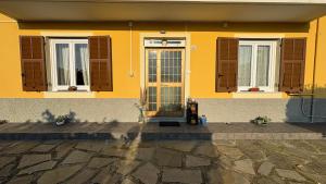 a yellow house with windows and a fire hydrant in front of it at Casa Maria in Serra Rocco