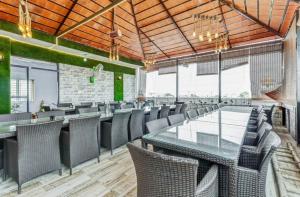 ein Esszimmer mit Tischen, Stühlen und Fenstern in der Unterkunft Lutino Homes Ramurthynagar main Road opposite D Mart in Bangalore