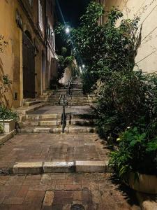 an alley with stairs and lights on a building at Beau studio au coeur du Panier in Marseille