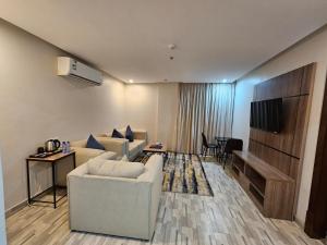 a living room with two white couches and a television at شقق اعمار الديار للشقق المخدومة in Jeddah