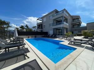 a swimming pool in front of a building at Villas Punta Silo - luxury apartments with pool in Šilo