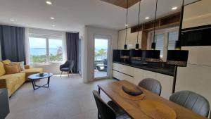 a kitchen and living room with a table and chairs at Villas Punta Silo - luxury apartments with pool in Šilo