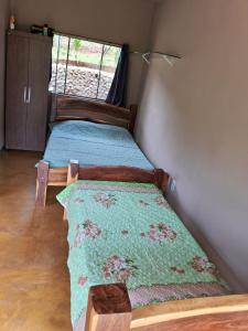 a bedroom with a bed with a green comforter at Chale2RabodeGalo in Santana do Riacho
