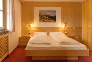 a bedroom with a large bed with two night stands at Puent Seceda-Dolomiti-Val Gardena in Ortisei +23 photos