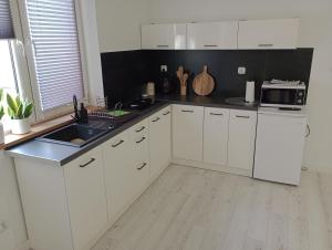 a white kitchen with a sink and a microwave at Skalny domek in Krościenko