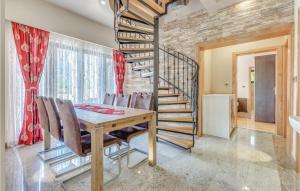 a dining room with a table and a spiral staircase at Nice Home In Bribir With Sauna in Bribir