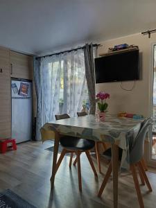 ein Esszimmer mit Tisch und Stühlen in der Unterkunft "Bungalow familial à Saint-Brevin-les-Pins avec piscine partagée" in Saint-Brevin-les-Pins