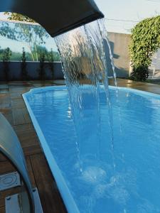 a swimming pool with a water fountain at Para Família - privacidade e lazer próximo ao lago de Itaipu in Foz do Iguaçu