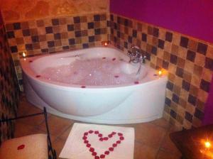 y baño con bañera con corazones pintados. en Casa Rural Las Albertas, en Arbancón