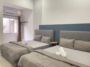 安顺Cozy Roomstay Teluk Intan的有两张床和一扇窗户的房间
