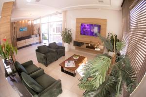 a living room with two couches and a tv at Hotel Fontana in Tapejara