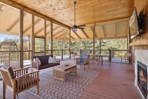 a screened porch with a fireplace and wooden ceiling at Woodland Cove in Waldens Creek