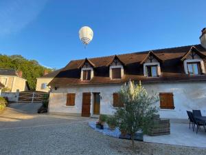 a house with a hot air balloon flying over it at LA MAISON DE TRIBOULET Chambres et table d'hôtes -Amboise- in Pocé-sur-Cisse