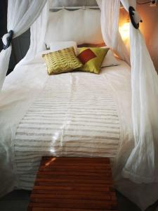 a large white bed with two pillows on it at La Balinaise in Saint-Jean-de-Védas