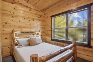 ein Schlafzimmer mit einem Bett in einer Blockhütte in der Unterkunft 10 minutes to Parkway, BunkBeds, Hot Tub, Firepit - Hidden Bear in Starkeytown