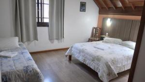 a bedroom with a bed and a couch in it at Pousada Genial in Gramado