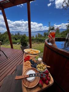 a tray of food on a table on a deck at Cabañas Ayalén con vista al Lago in Pucón