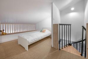 ein Schlafzimmer mit einem weißen Bett und einer Treppe in der Unterkunft À 400m de la plage, maison renovée pour 6 in Préfailles
