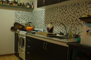 a kitchen with a sink and a stove at Habitación privada en Esquel in Esquel