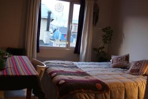 a bed in a room with a window at Habitación privada en Esquel in Esquel