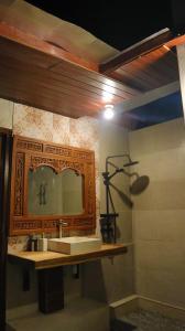 ein Badezimmer mit Waschbecken und Spiegel in der Unterkunft Pranajaya oasis in Tejakula