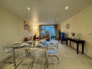 Una sala de estar con una mesa de cristal y sillas. en Two Bed Flat In Wimbledon, en Londres
