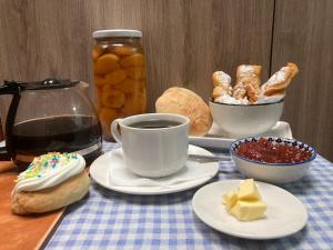 a table topped with plates of pastries and a cup of coffee at Hostal Sol Temuco in Temuco